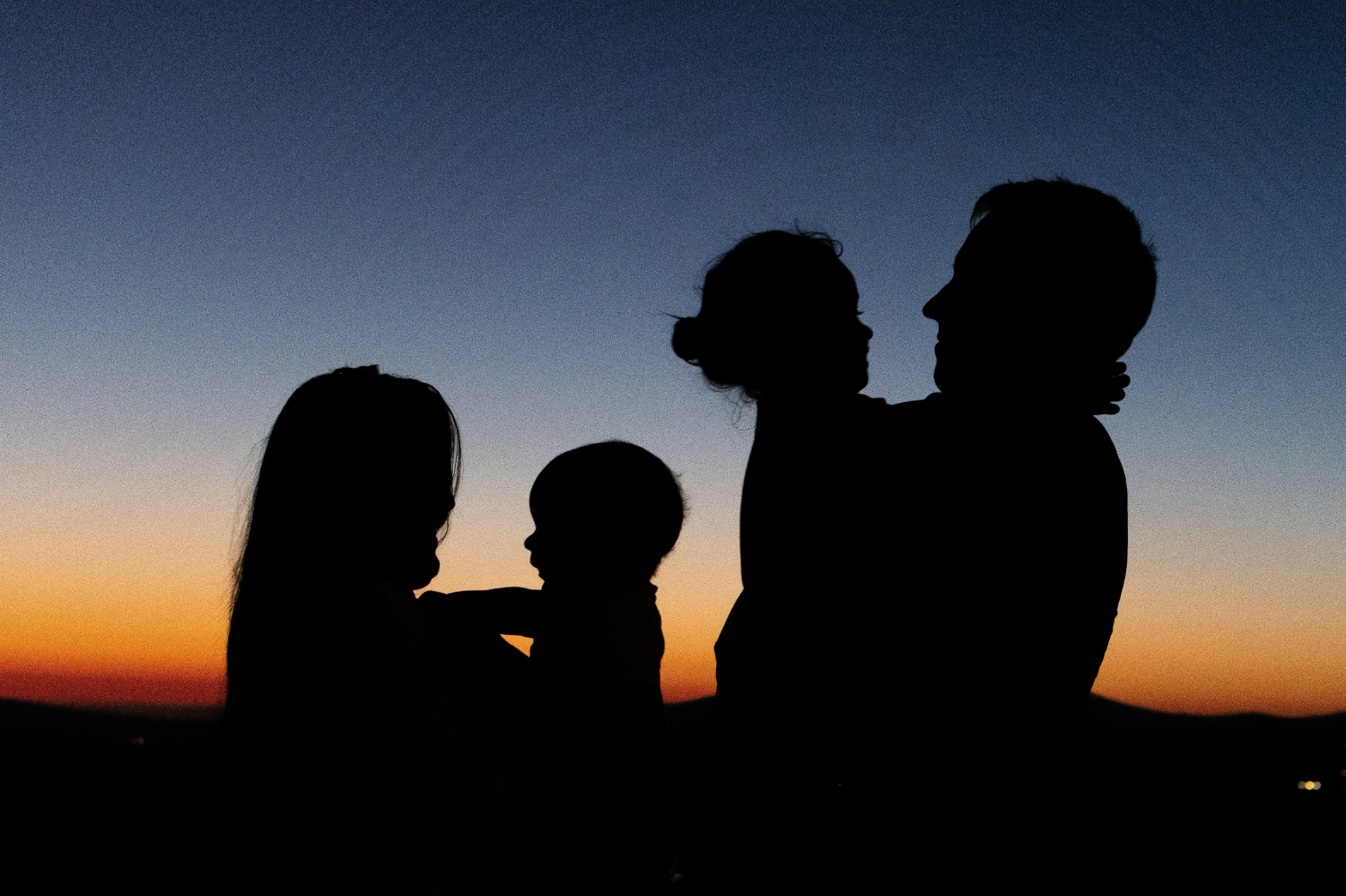 A family silhouetted against the sunset